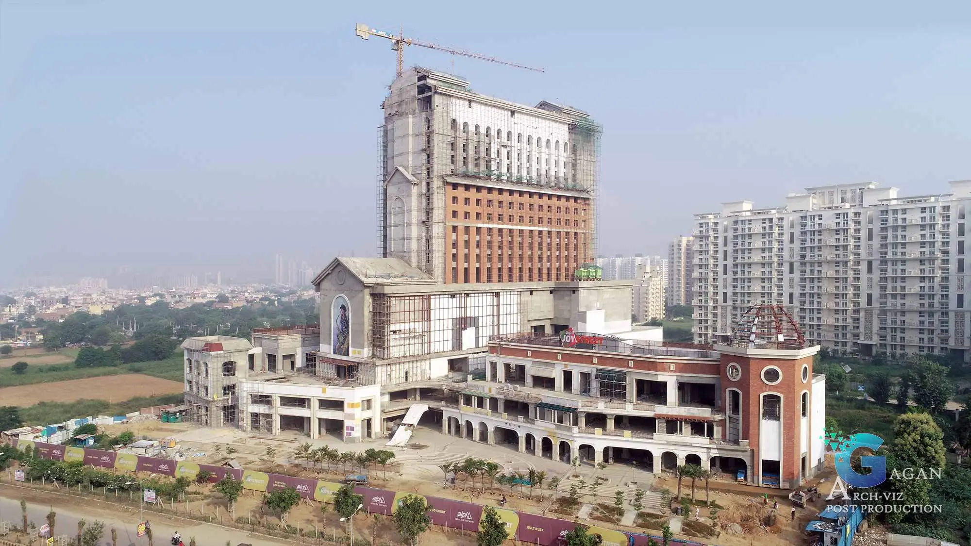 "Photorealistic image of a construction site for a large building, featuring multiple sections including a tall tower with a crane, a lower section with a mural, and a dome-like structure. Surrounding elements include fencing, trees, and a road in the foreground, with a background of high-rise buildings and a cityscape. Post-production edits enhance vivid lighting, detailed textures, and sharp contrast, emphasizing the architectural design and the progress of construction